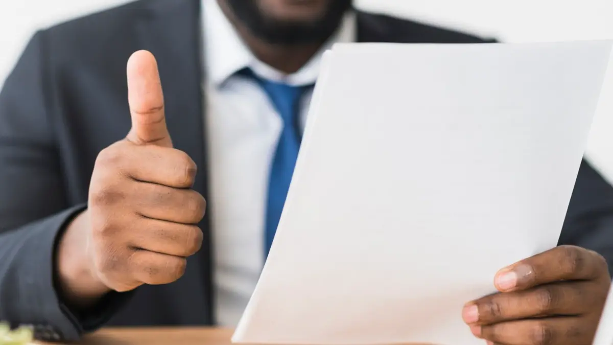 Man giving thumbs-up while reviewing a document, representing confidence in TeamMate's Operator Connect Express to enable calling.